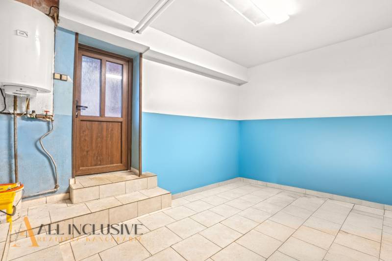 NA PREDAJ 4-IZBOVÝ RODINNÝ DOM V OBCI ŠINTAVA - Interiér rodinného domu s modrými stenami a svetlou podlahou vedľa drevených dverí.