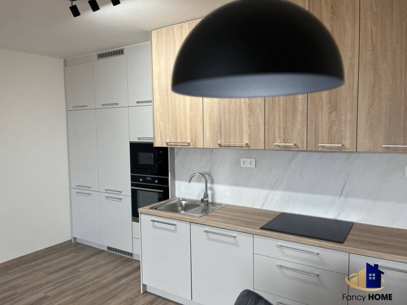 2 izbový byt na prenájom v centre Košíc  - Kuchyňa v 2-izbovom byte s podlahou s dreveným dekorom a svetlým nábytkom.