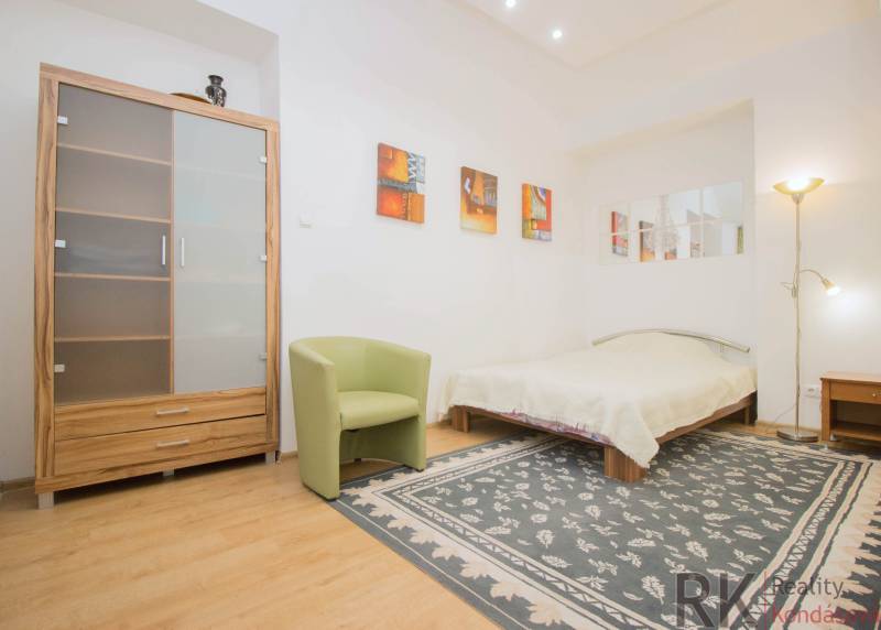 Centrum Košíc - 2-izb.tehlový byt s parkovaním vo dvore - Spálňa v 2-izbovom byte so podlahou s dreveným dekorom, kobercom a posteľou.