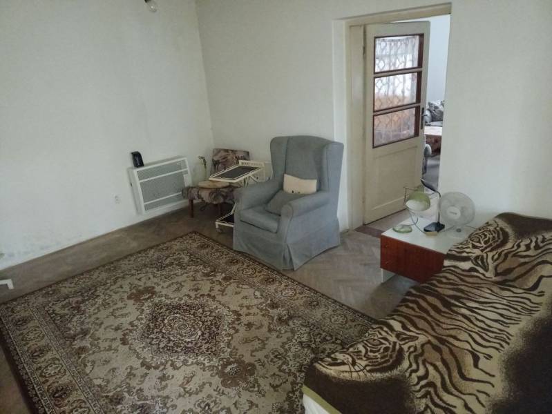 Predám Rodinný dom v Strekove - Izba v rodinnom dome s kobercom, kreslami a posteľou.