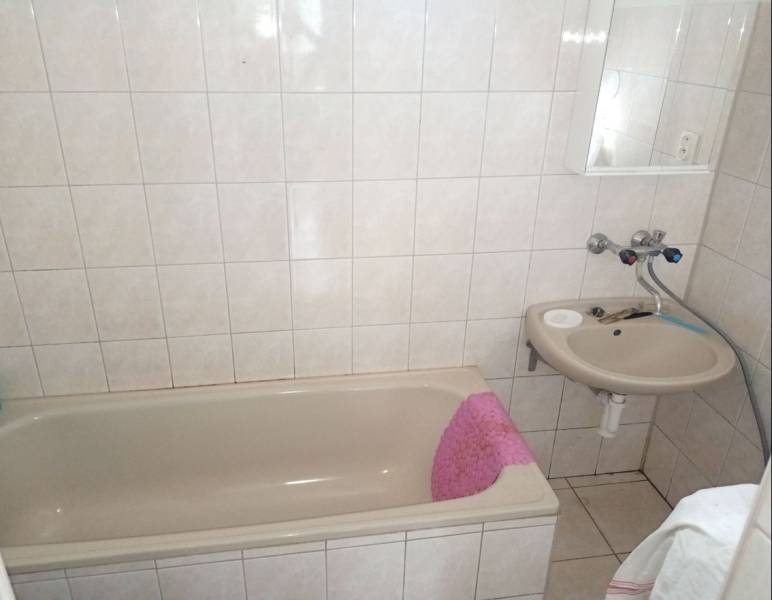 Predám Rodinný dom v Strekove - Kúpeľňa s vaňou a umývadlom v rodinnom dome, svetlé obklady a dlažba.