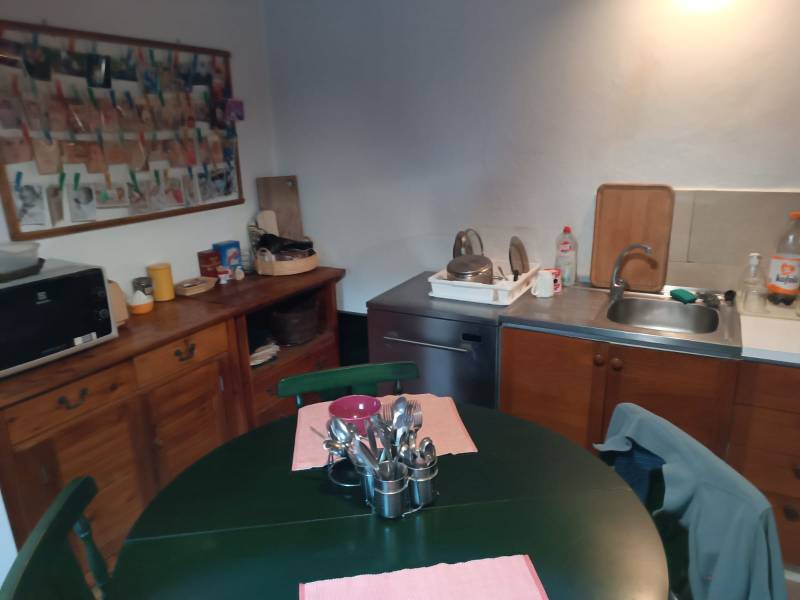 Samota Nová Baňa – Štále s hospodárskymi stavbami  - Kuchyňa v rodinnom dome s drevenou komodou, jedálenským stolom a umývadlom.