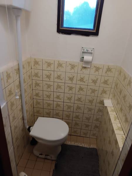 Samota Nová Baňa – Štále s hospodárskymi stavbami  - Na obrázku je tradičná kúpeľňa v rodinnom dome s toaletou a dlažbou.