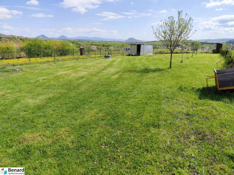 NA PREDAJ PEKNÝ OPLOTENÝ POZEMOK 719m2, SABINOV  - Rozľahlý trávnik s niekoľkými stromami na pozemkoch určených na bývanie v Sabinove.