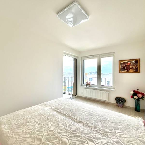 Súčasný 2-izbový byt v novostavbe – Matadorka  - Svetlá izba v dvojgarsónke s oknami, výraznou posteľou a dekoráciami.