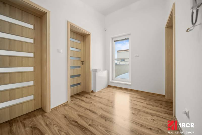 MODERNÝ 5-IZBOVÝ RODINNÝ DOM V ČUNOVE: 180m2 KOMFORTU A TICHA - Interiér rodinného domu s podlahou s dreveným dekorom a dverami s presklením.