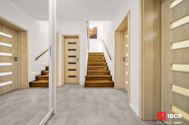 MODERNÝ 5-IZBOVÝ RODINNÝ DOM V ČUNOVE: 180m2 KOMFORTU A TICHA - Vstupná hala v rodinnom dome s podlahou s dreveným dekorom a schodiskom.