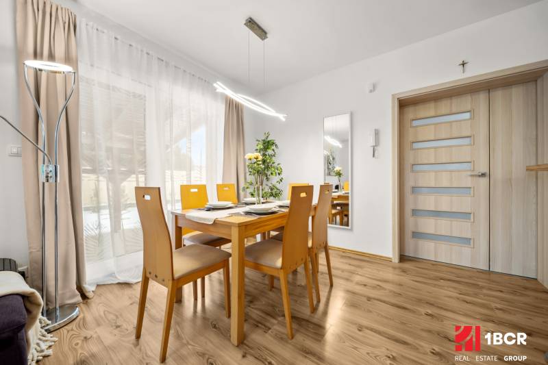 MODERNÝ 5-IZBOVÝ RODINNÝ DOM V ČUNOVE: 180m2 KOMFORTU A TICHA - Jedáleň s dreveným stolom a podlahou s dreveným dekorom v rodinnom dome.