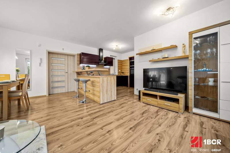 MODERNÝ 5-IZBOVÝ RODINNÝ DOM V ČUNOVE: 180m2 KOMFORTU A TICHA - Obývačka v rodinnom dome s kuchyňou a podlahou s dreveným dekorom.