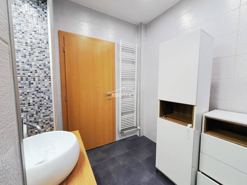 Prenájom, 2-izbový byt, M.R.Štefánika, Exkluzívne Reality IQ  - Kúpeľňa s umývadlom, bielymi skrinkami a mozaikovým obkladom v 2-izbovom byte.