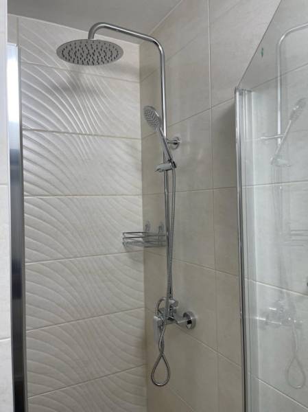 REZERVOVANÉ! Nadštandardný 1-izbový byt, ul. 1. mája, Vráble - Sprchový kút v 1-izbovom byte, obloženie s textúrou a sklenenou stenou.