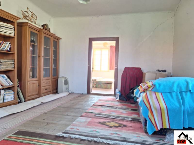 Všetko po čom túžite - dom, relax, kúpele, kúpalisko - Izba v rodinnom dome s regálmi na knihy, posteľou s farebnou dekou a kobercom.