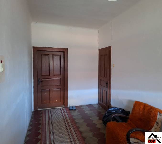 Všetko po čom túžite - dom, relax, kúpele, kúpalisko - Interiér rodinného domu s dverami, kreslom a kobercovým chodníkom.