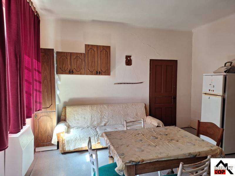 Všetko po čom túžite - dom, relax, kúpele, kúpalisko - Interiér rodinného domu s pohovkou, jedálenským stolom a drevenými skrinkami.