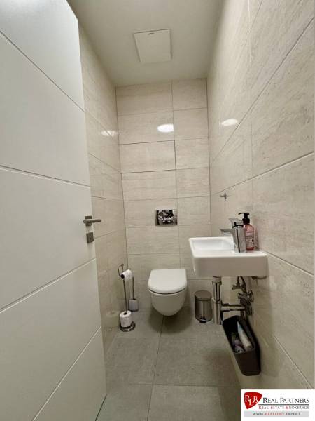 Prenájom 2-izbového bytu CUBICON  - Toaleta s dlaždicami a malým umývadlom v 2-izbovom byte.