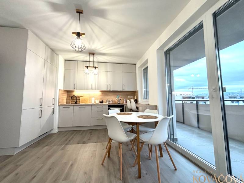 Na prenájom 3 izb. byt, Trenčín, ul.Vl.Predmerského, park.miesto,garáž - Kuchyňa v 3-izbovom byte s podlahou s dreveným dekorom a balkónom.