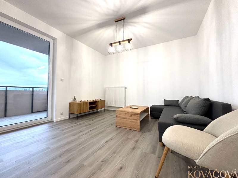 Na prenájom 3 izb. byt, Trenčín, ul.Vl.Predmerského, park.miesto,garáž - Obývacia izba s pohovkou, kreslom, stolíkom a podlahou s dreveným dekorom v 3-izbovom byte.