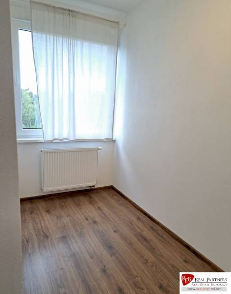 Prenájom útulný 2,5-izbový byt so záhradkou Vajnory - Jednoduchá izba v 3-izbovom byte s podlahou s dreveným dekorom.