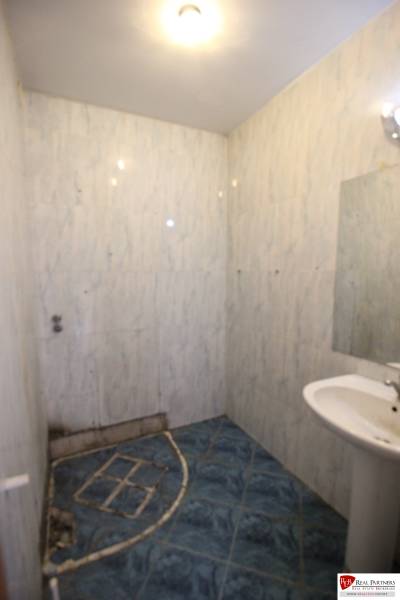 Ponúka na predaj budovu - centrum Senca - NOVÁ SUPER CENA  - Kúpeľňa s modrou dlažbou, umývadlom a jednoduchým osvetlením; na ulici Mierové nám.