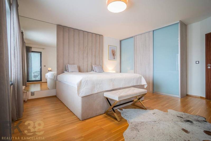 Výhodná cena: Rodinný dom v tichej lokalite v obci Spišské Bystré - Spálňa v rodinnom dome s posteľou, podlahou s dreveným dekorom a kožušinovým kobercom.