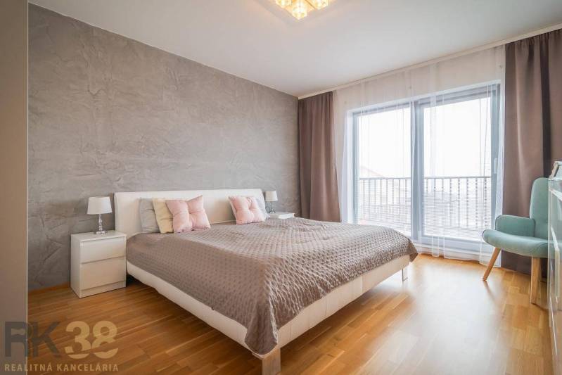 Výhodná cena: Rodinný dom v tichej lokalite v obci Spišské Bystré - Spálňa v rodinnom dome s posteľou, nočnými stolíkmi a podlahou s dreveným dekorom.