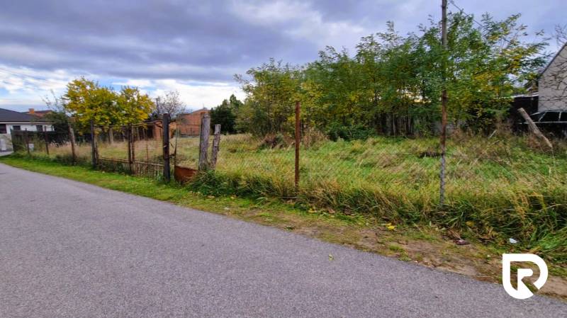 Stavebný pozemok 882 m² | Gajary - Pozemky na bývanie v Gajaroch s viditeľným plotom a okolitými stromami, ponúkajú pokoj.