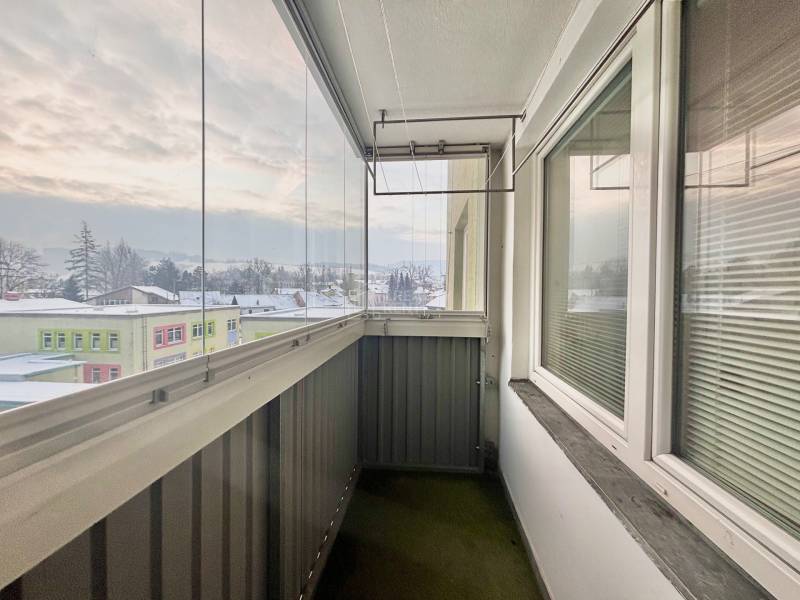 Predaj: Veľkometrážny 3+1 byt v Turzovke - Zasklený balkón s pohľadom na zasneženú panorámu mesta Turzovka na ulici Centrum.