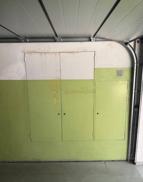 Garáž ul. Eisnerova, Devínska Nová Ves - Garáž v bielej a zelenej farbe má členené úložné skrinky.