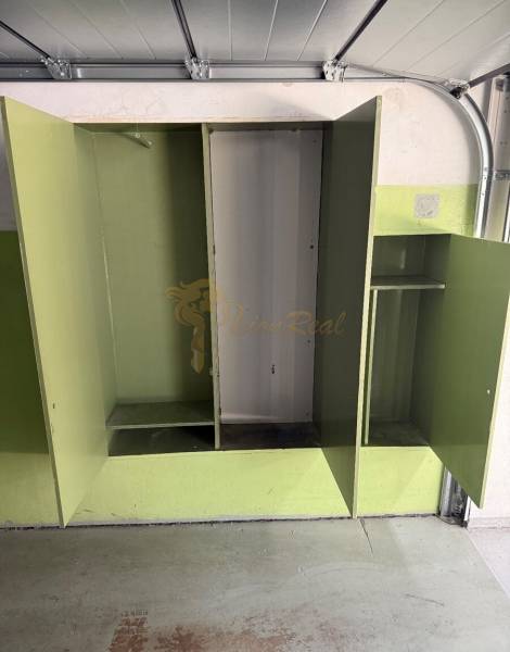 Garáž ul. Eisnerova, Devínska Nová Ves - Otvorené zelené skrine v garáži s podlahou na uzavretie.