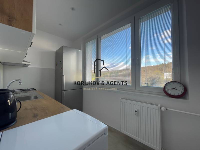 PRENÁJOM, 3 izbový byt na Fábryho ulici, Košice - Dargovských Hrdinov - Kuchyňa v 3-izbovom byte s výhľadom cez žalúzie, jednoduché zariadenie a spotrebiče.