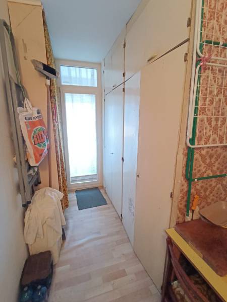 Na predaj veľkometrážny 3 izbový byt Žarnovica - Úzka chodba s podlahou s dreveným dekorom, skriňami a dverami v 3-izbovom byte.