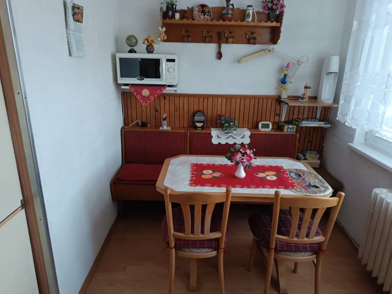 Na predaj veľkometrážny 3 izbový byt Žarnovica - Kuchyňa v 3-izbovom byte s dreveným dekorom podlahy a rustikálnou výzdobou.