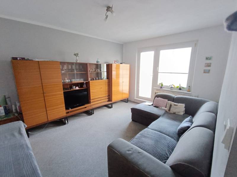 Na predaj veľkometrážny 3 izbový byt Žarnovica - Obývacia izba v 3-izbovom byte s pohovkou a veľkou skriňovou zostavou.