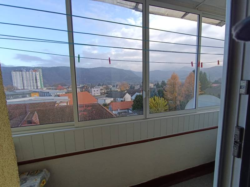 Na predaj veľkometrážny 3 izbový byt Žarnovica - Výhľad z 3-izbového bytu na Fraňa Kráľa v Žarnovici s panorámou mesta a hôr.