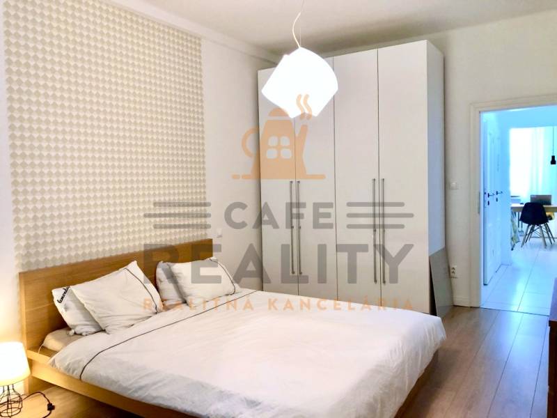 Na prenájom 2 izbový byt, 56 m2, Bratislava, Staré Mesto, Björnsonova - Spálňa v 2-izbovom byte s bielou skriňou a podlahou s dreveným dekorom.