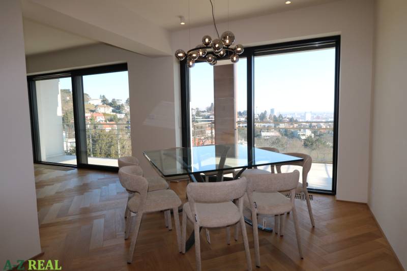 Prenájom 4 izbového bytu s krásnym výhľadom na mesto - Jedáleň v 4-izbovom byte s presklenou stenou a podlahou s dreveným dekorom.
