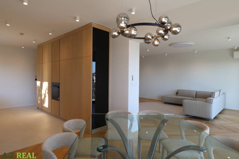 Prenájom 4 izbového bytu s krásnym výhľadom na mesto - Obývacia izba s jedálenským stolom, pohovkou a svietidlom v 4-izbovom byte, podlaha s dreveným dekorom.