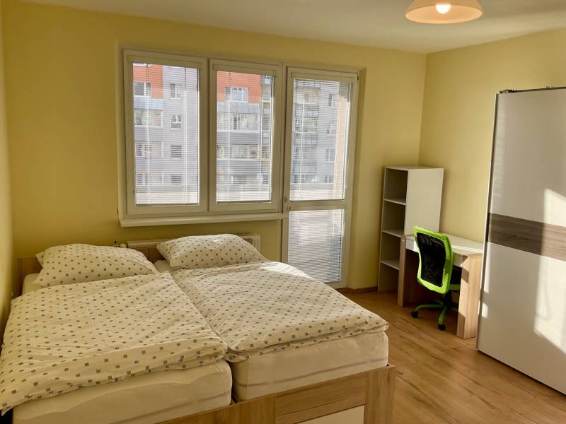 I prenájom štýlových izieb v 3-izbovom byte – Karlova Ves - Spálňa s dvojposteľou, pracovným stolom a podlahou s dreveným dekorom v 3-izbovom byte.