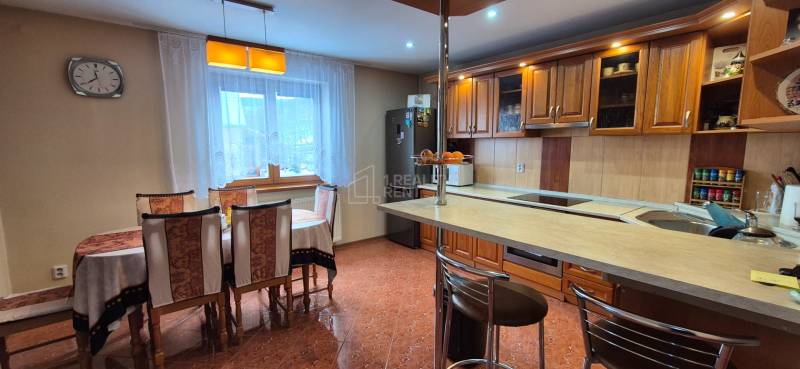 Predaj: Rodinný dom po rekonštrukcii s nadstavbou v Ochodnici (RCZ) - Kuchyňa s jedálenským stolom v rodinnom dome, drevené skrinky a podlaha s dlažbou.