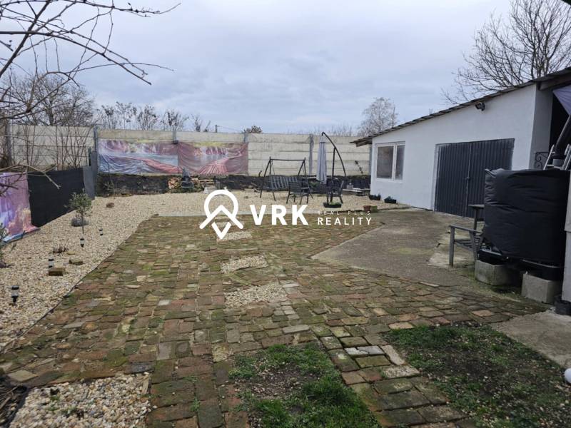 RODINNÝ DOM, HERNÁDKAK, MAĎARSKO - Dvor rodinného domu v Hernádkaku s dlažbou a vonkajším posedením na pozemku.