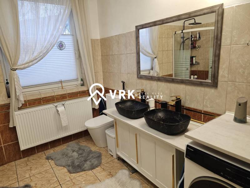 RODINNÝ DOM, HERNÁDKAK, MAĎARSKO - Kúpeľňa v rodinnom dome s dvojitým umývadlom, vaňou a práčkou na dlažbe.