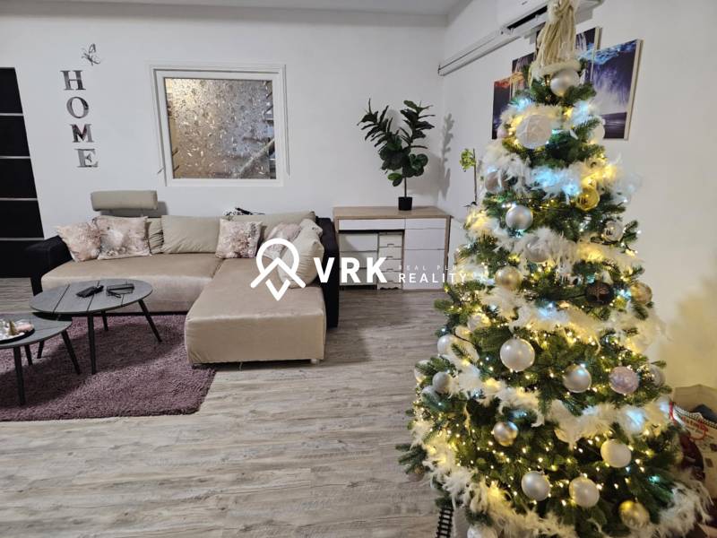 RODINNÝ DOM, HERNÁDKAK, MAĎARSKO - V rodinnom dome s podlahou s dreveným dekorom je ozdobený vianočný stromček a sedačka.