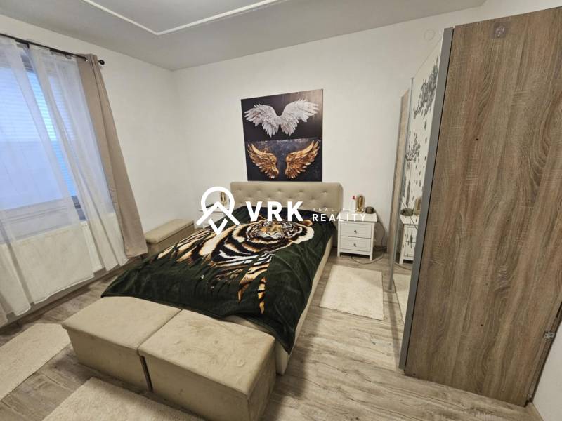 RODINNÝ DOM, HERNÁDKAK, MAĎARSKO - Spálňa s posteľou, skriňou a podlahou s dreveným dekorom v rodinnom dome.