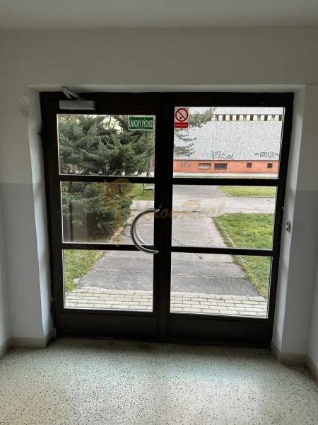 2-izb. byt, Nejedlého, Dúbravka, izby samostatné - Sklenené vchodové dvere z interiéru, východ vedie k upravenému trávniku a chodníku.