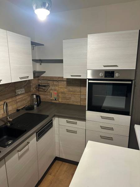 2-izb. byt, Nejedlého, Dúbravka, izby samostatné - Kuchyňa v 2-izbovom byte, s podlahou s dreveným dekorom a vstavanou rúrou.