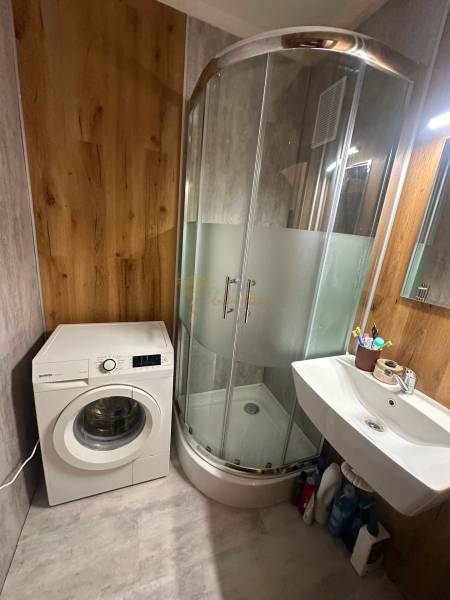 2-izb. byt, Nejedlého, Dúbravka, izby samostatné - Kúpeľňa v 2-izbovom byte s práčkou, sprchovým kútom a umývadlom, drevený dekor stien.