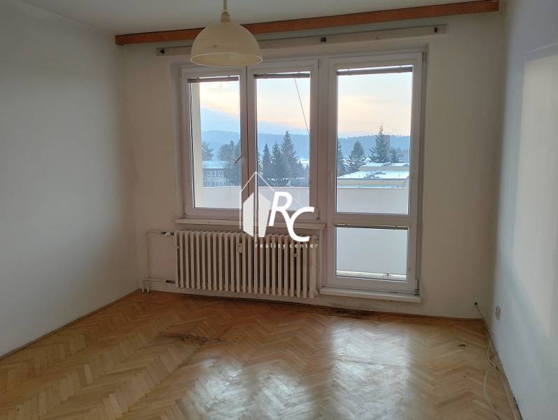 2-izbový byt s lodžiou, Turčianske Teplice - Izba so svetlým interiérom a podlahou s dreveným dekorom v 2-izbovom byte.