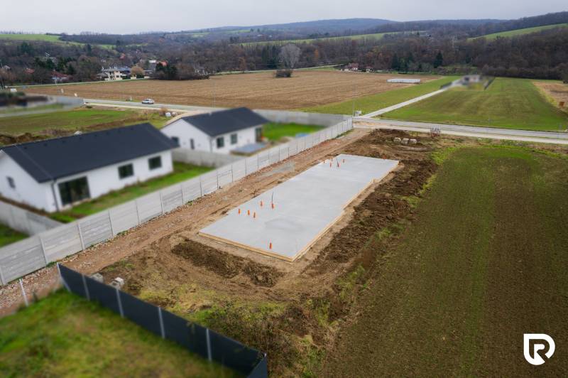 Moderná novostavba 4-izbového domu – Sokolovce  - Základy rodinného domu v Sokolovciach, obklopené poliami a susednými domami.