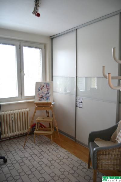 Útulný 3-izbový byt v Trnave na skok do Kamenáča! - Jednoduchý interiér 3-izbového bytu s kreslom, stolčekom a skriňou.