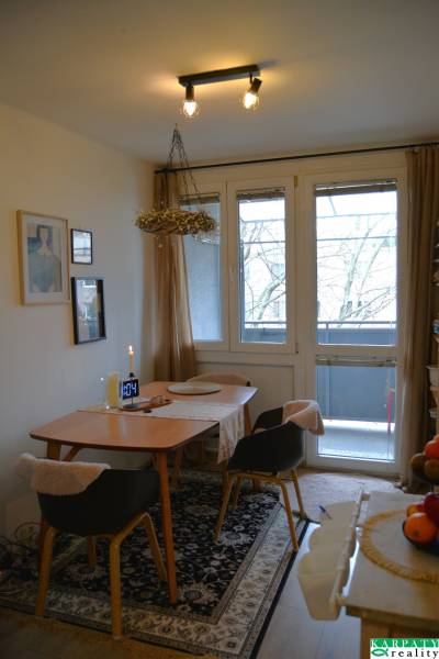 Útulný 3-izbový byt v Trnave na skok do Kamenáča! - Jedálenský kút v 3-izbovom byte s kobercovým dekorom a prosklenými dverami na balkón.
